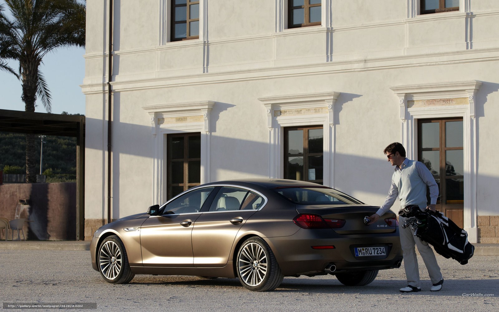 man with golf bag near car