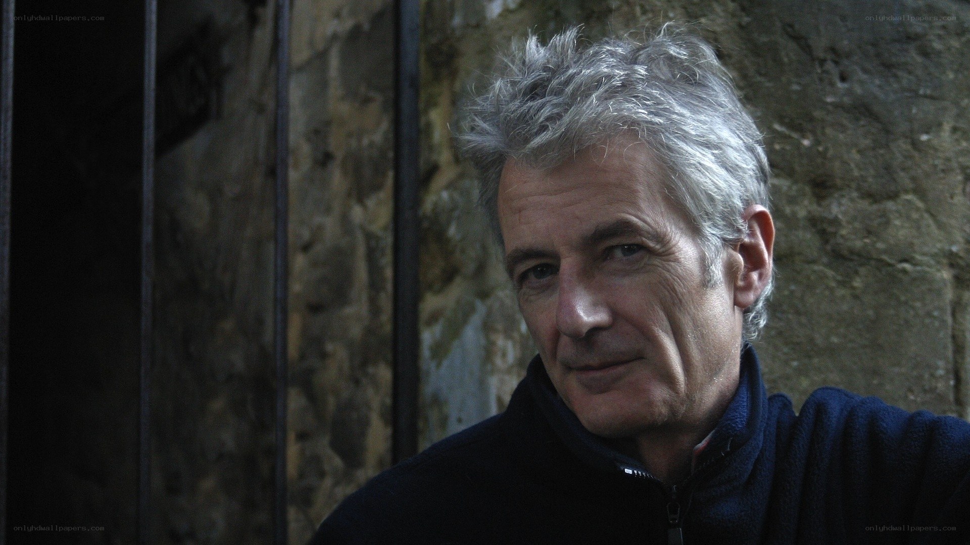 man with gray hair in dark setting