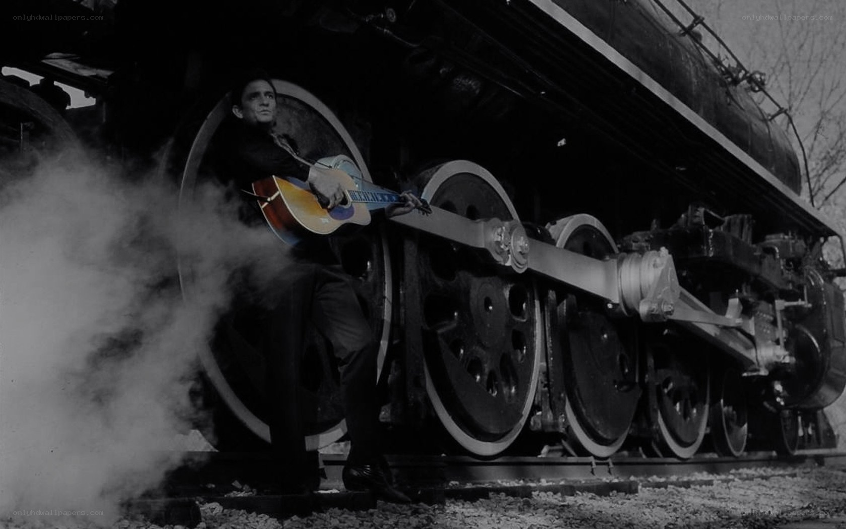Man with guitar by steam train