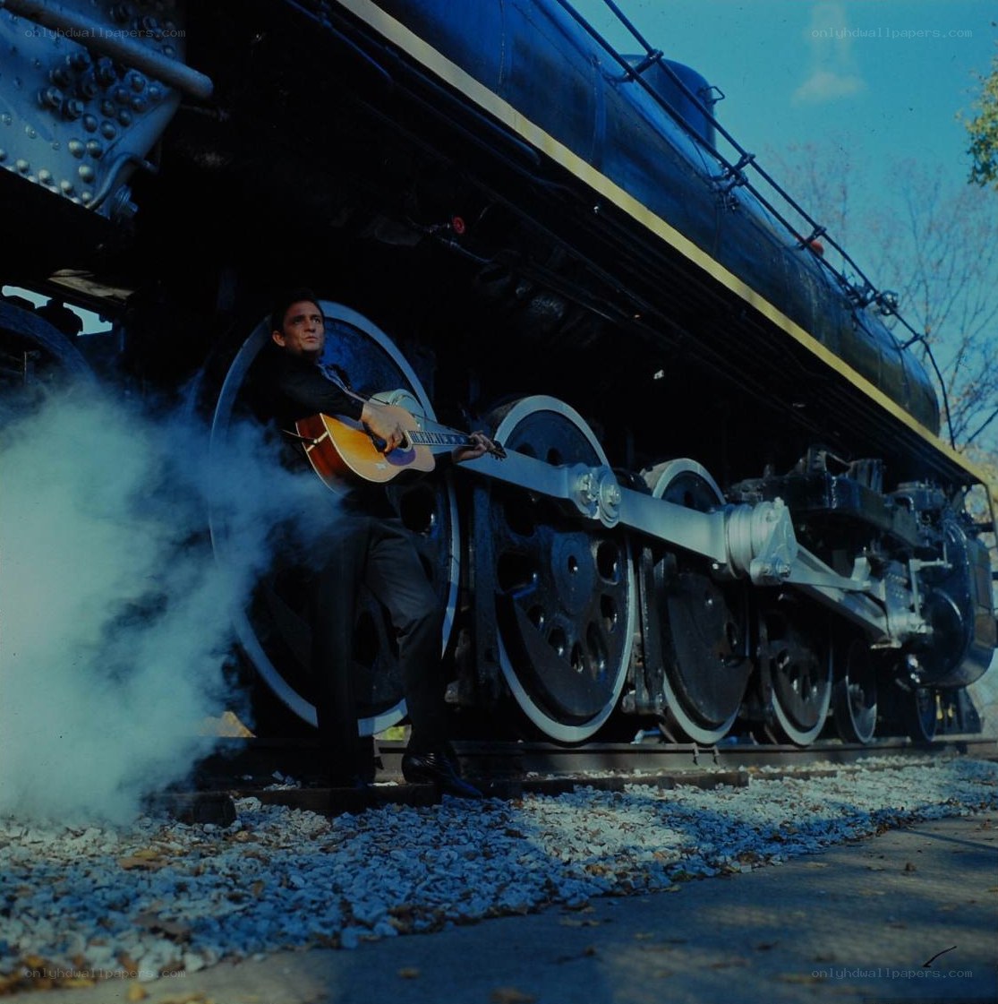 man with guitar by train
