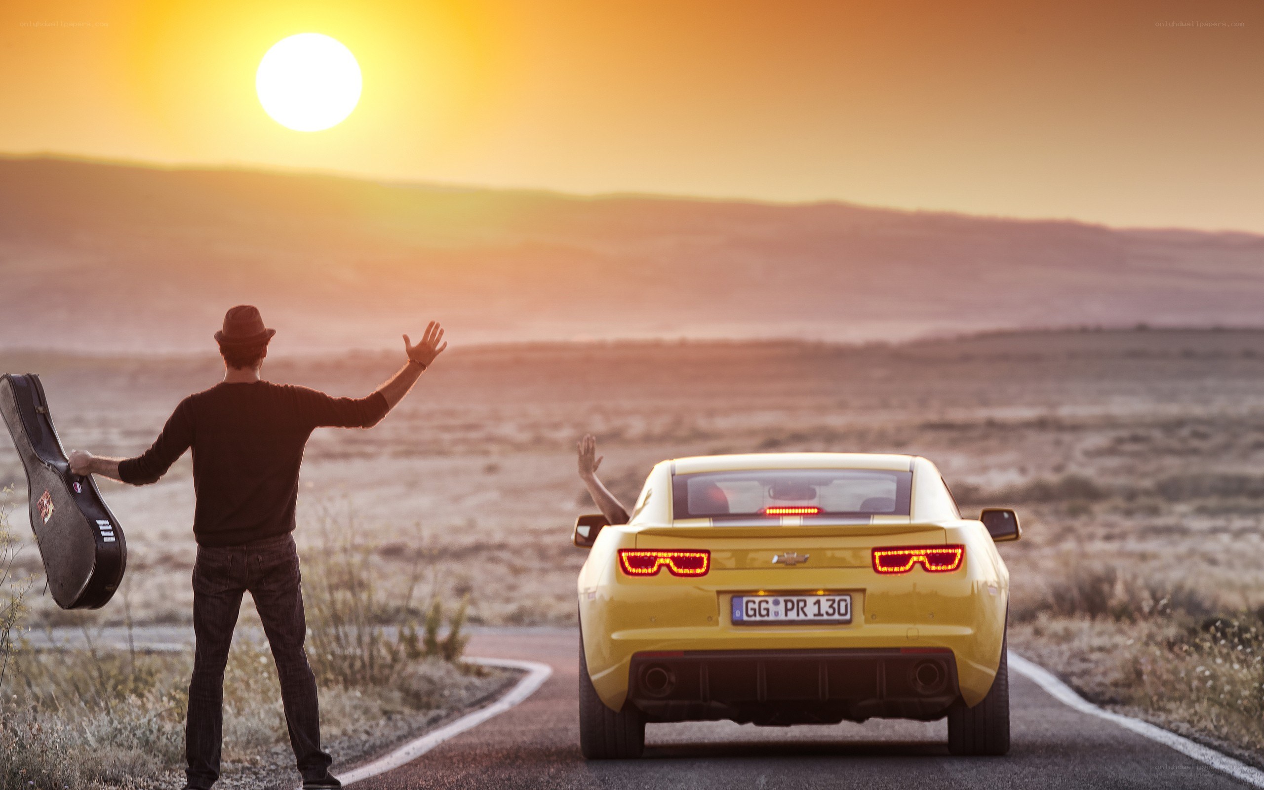 Man with guitar hails a car
