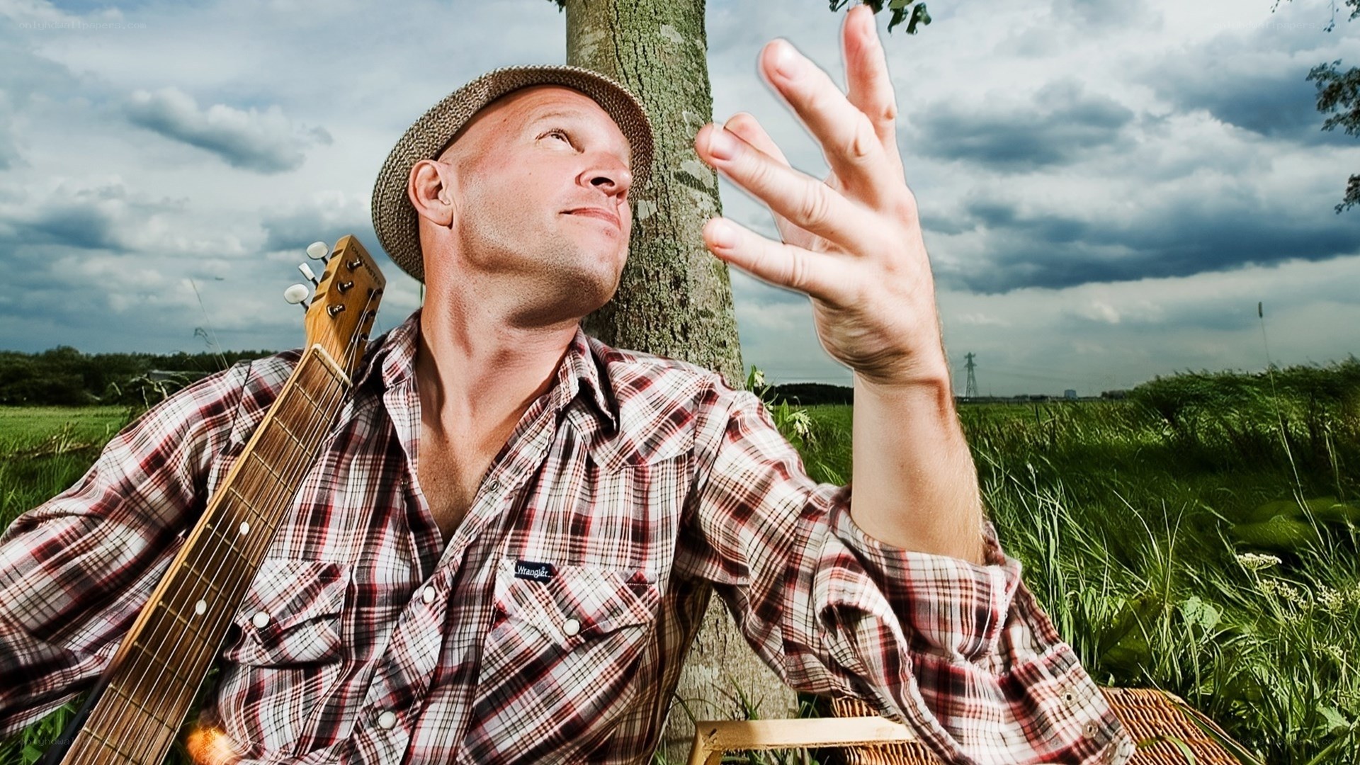 man with guitar in field