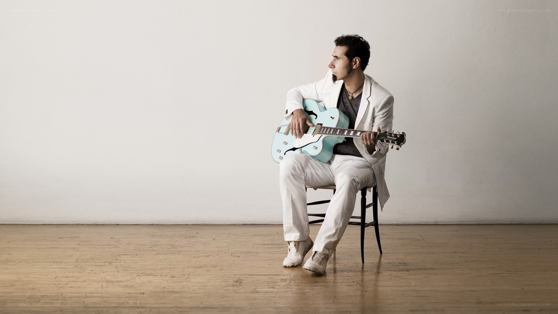 Man with guitar in white suit
