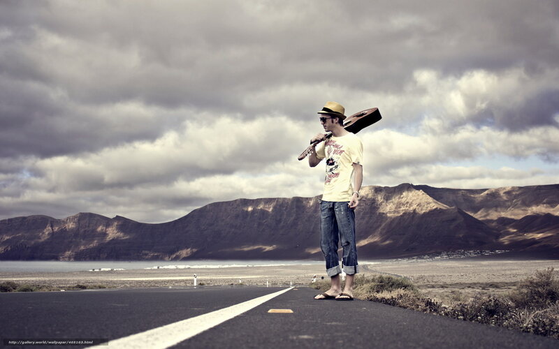 Man with guitar on road