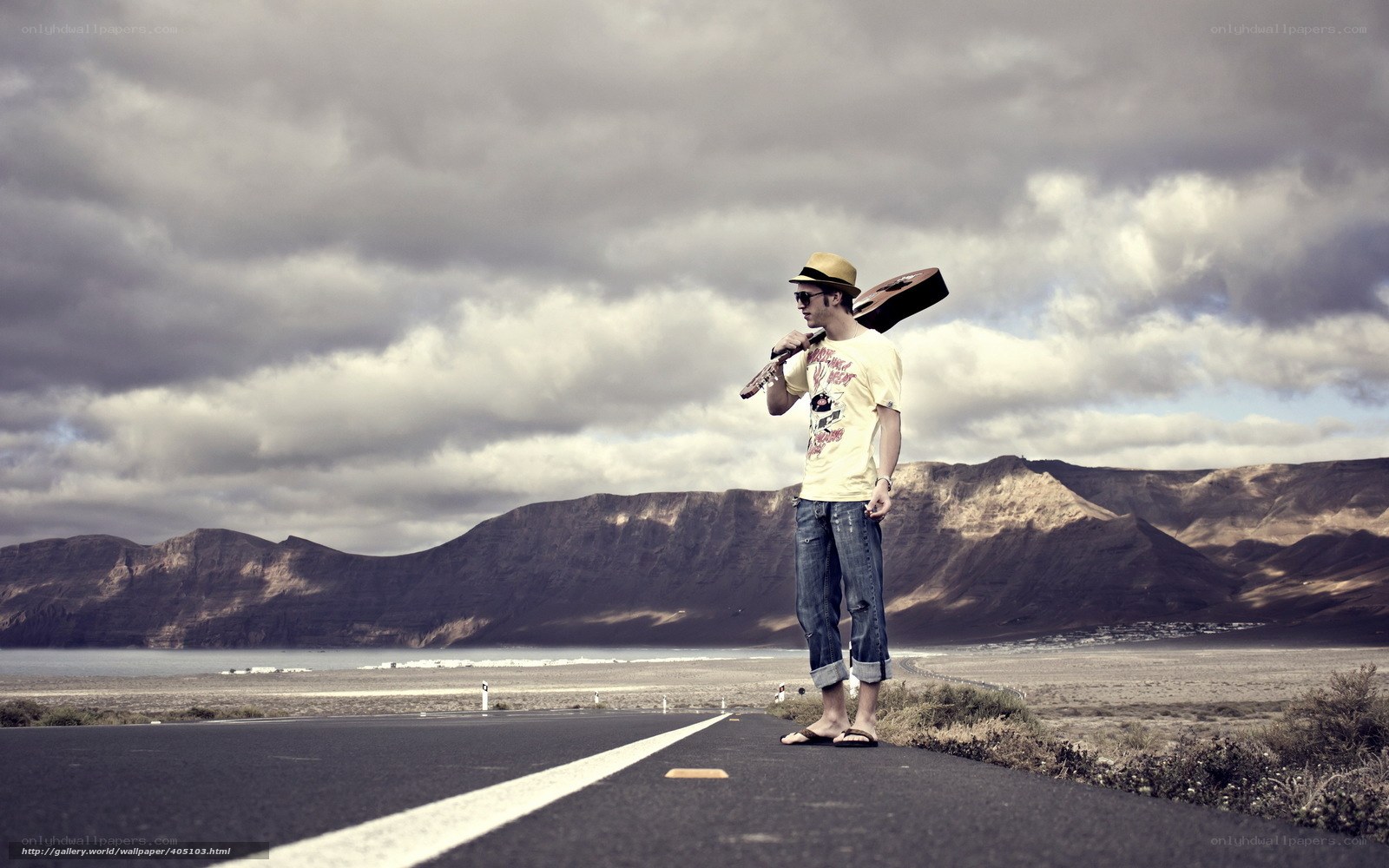 Man with guitar on road