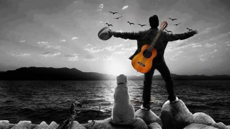 Man with Guitar on Rocks