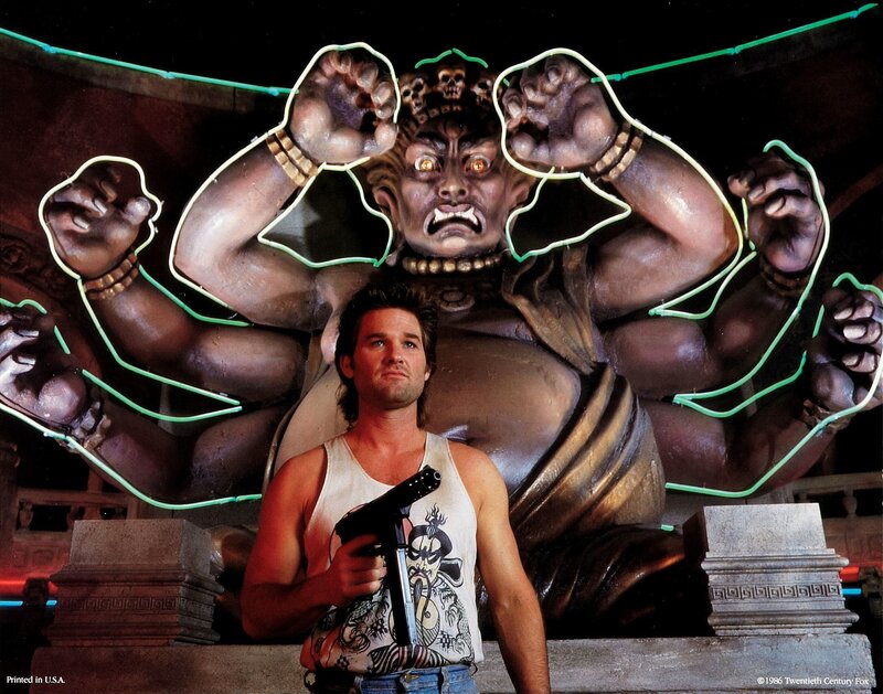 Man with gun in front of statue