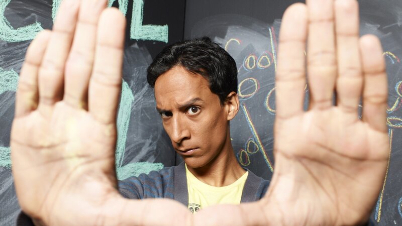 Man with hands up in front of chalkboard
