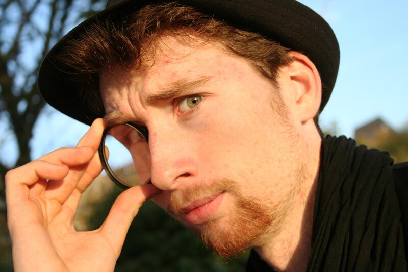man with hat holding lens