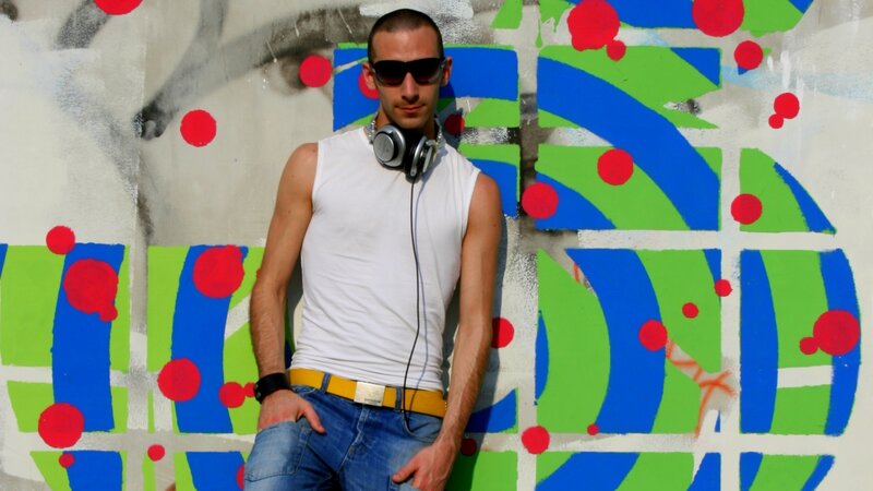 Man with headphones against graffiti wall