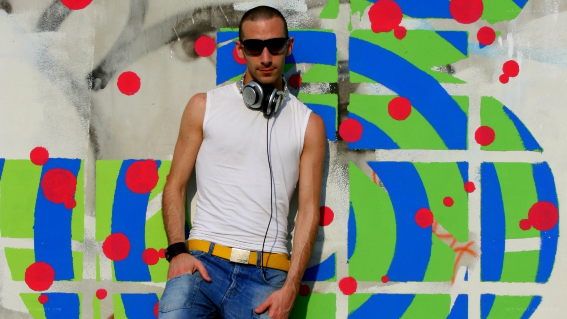 Man with headphones against graffiti wall
