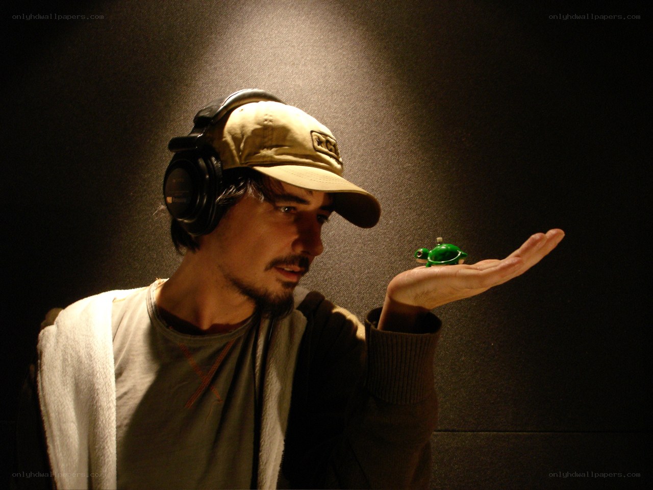 man with headphones holding turtle