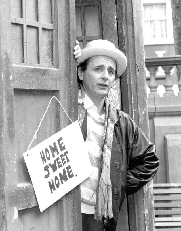 Man with home sign in doorway