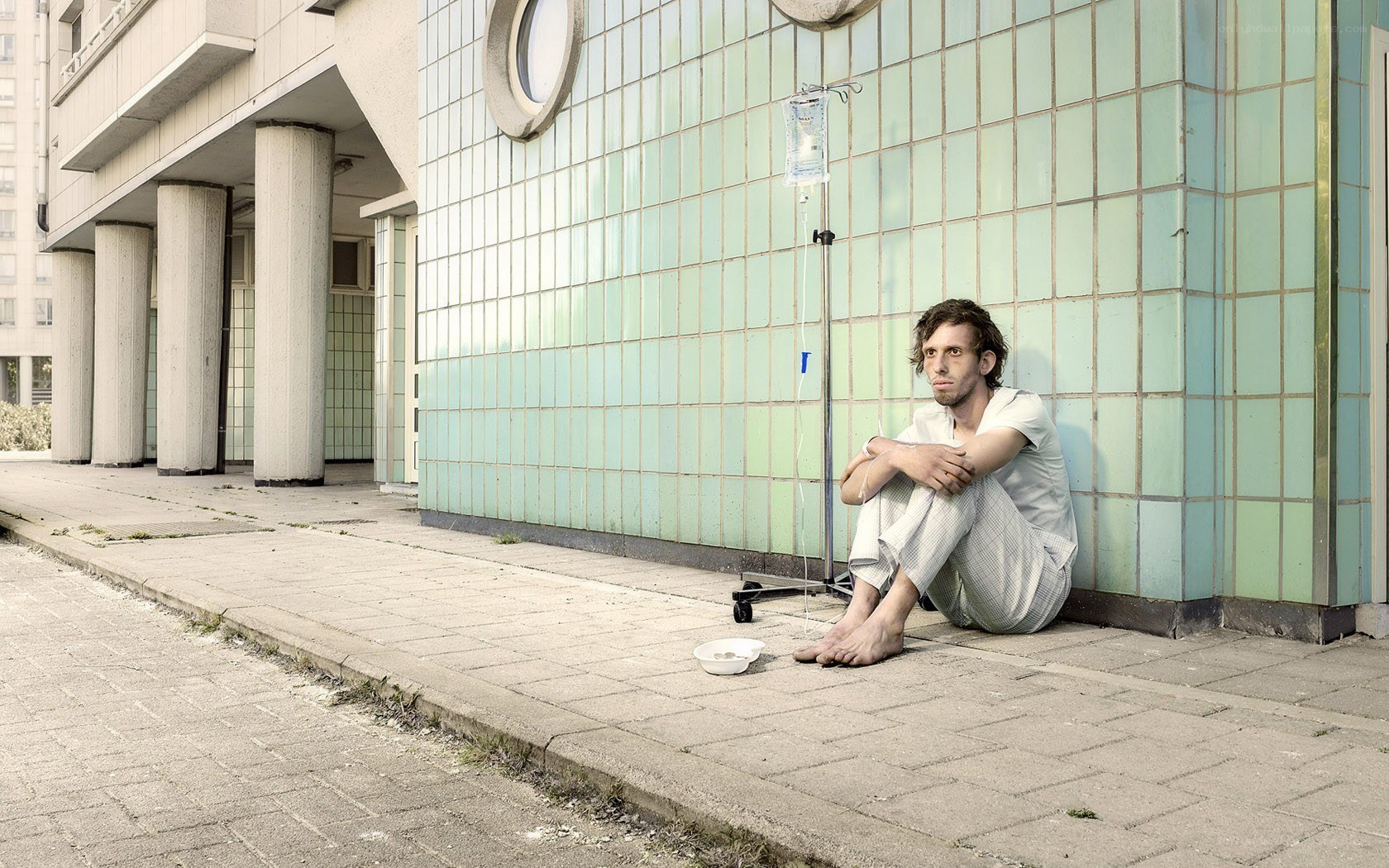 Man with IV bag outside hospital