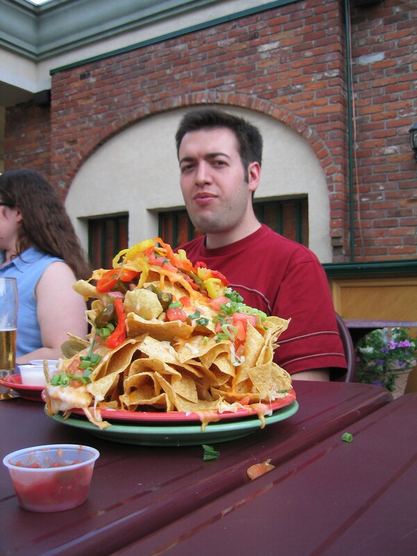Man with large nachos at table