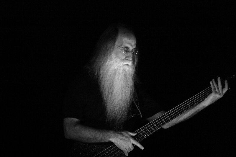 man with long beard playing bass guitar