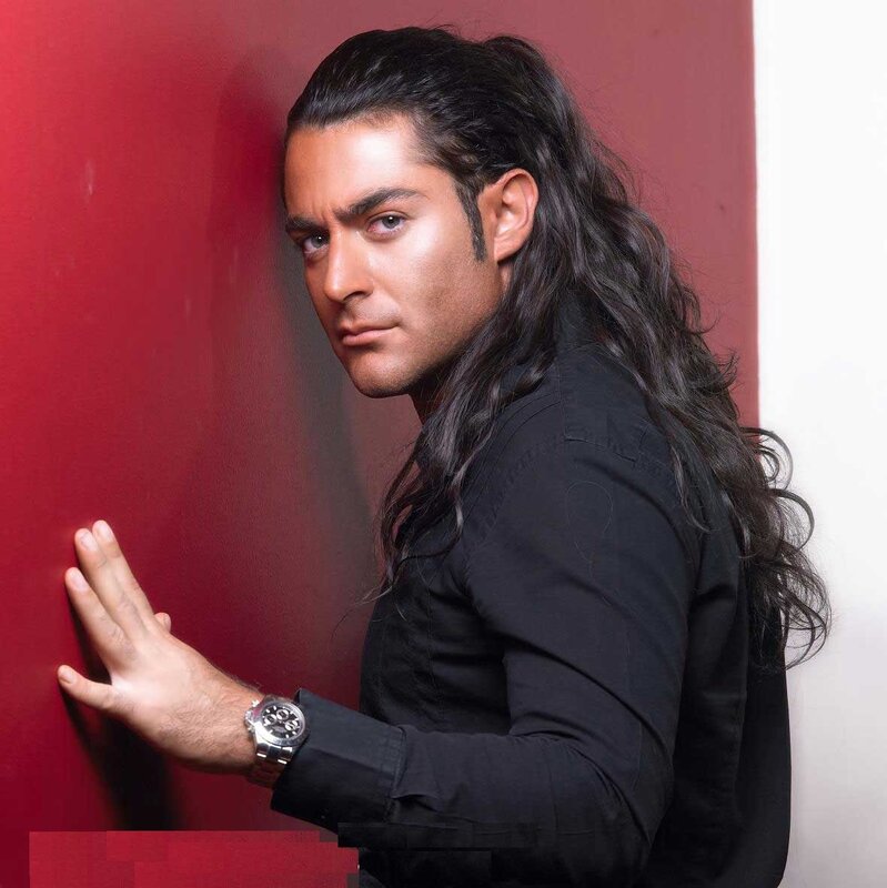 man with long hair against red wall