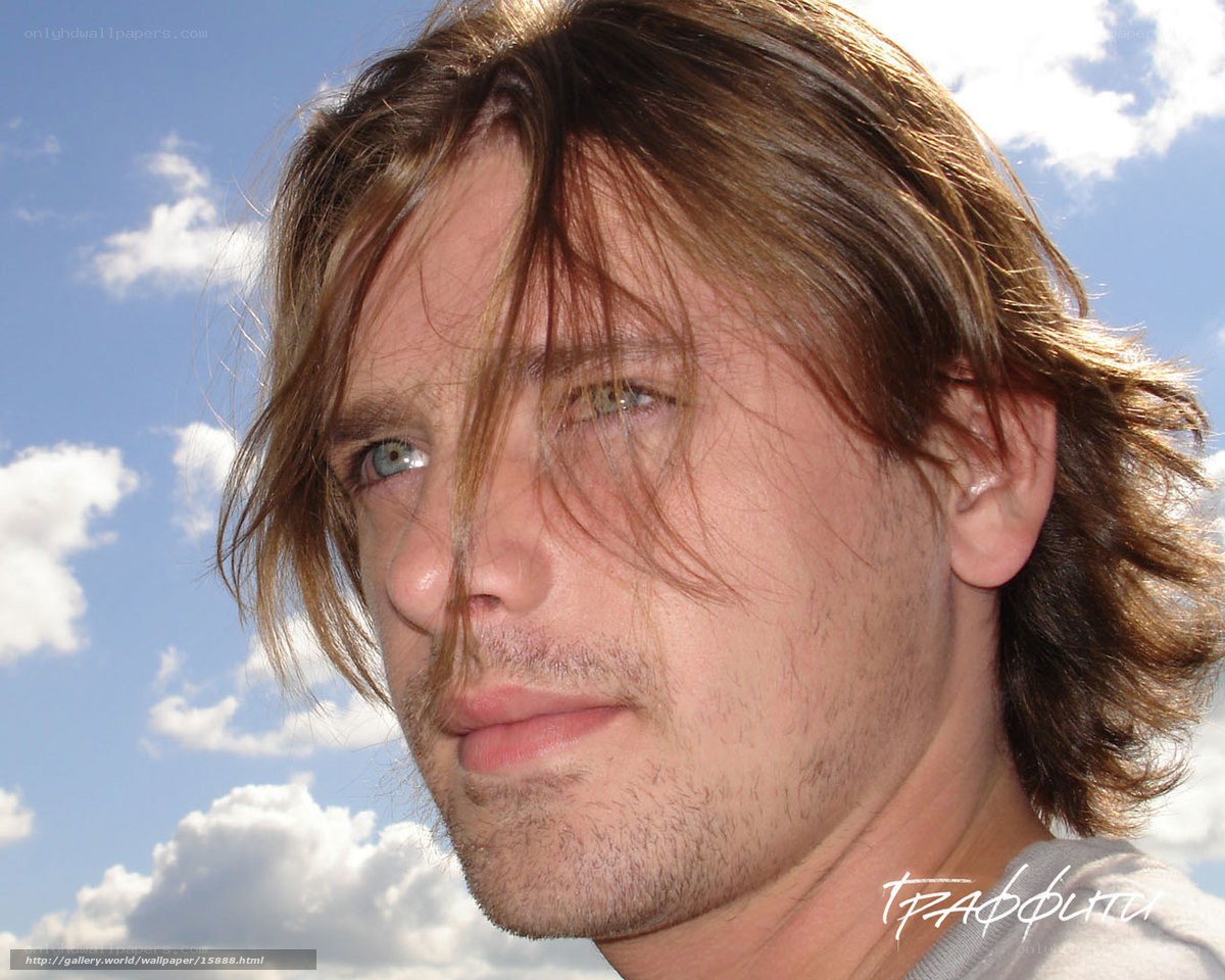 man with long hair against sky