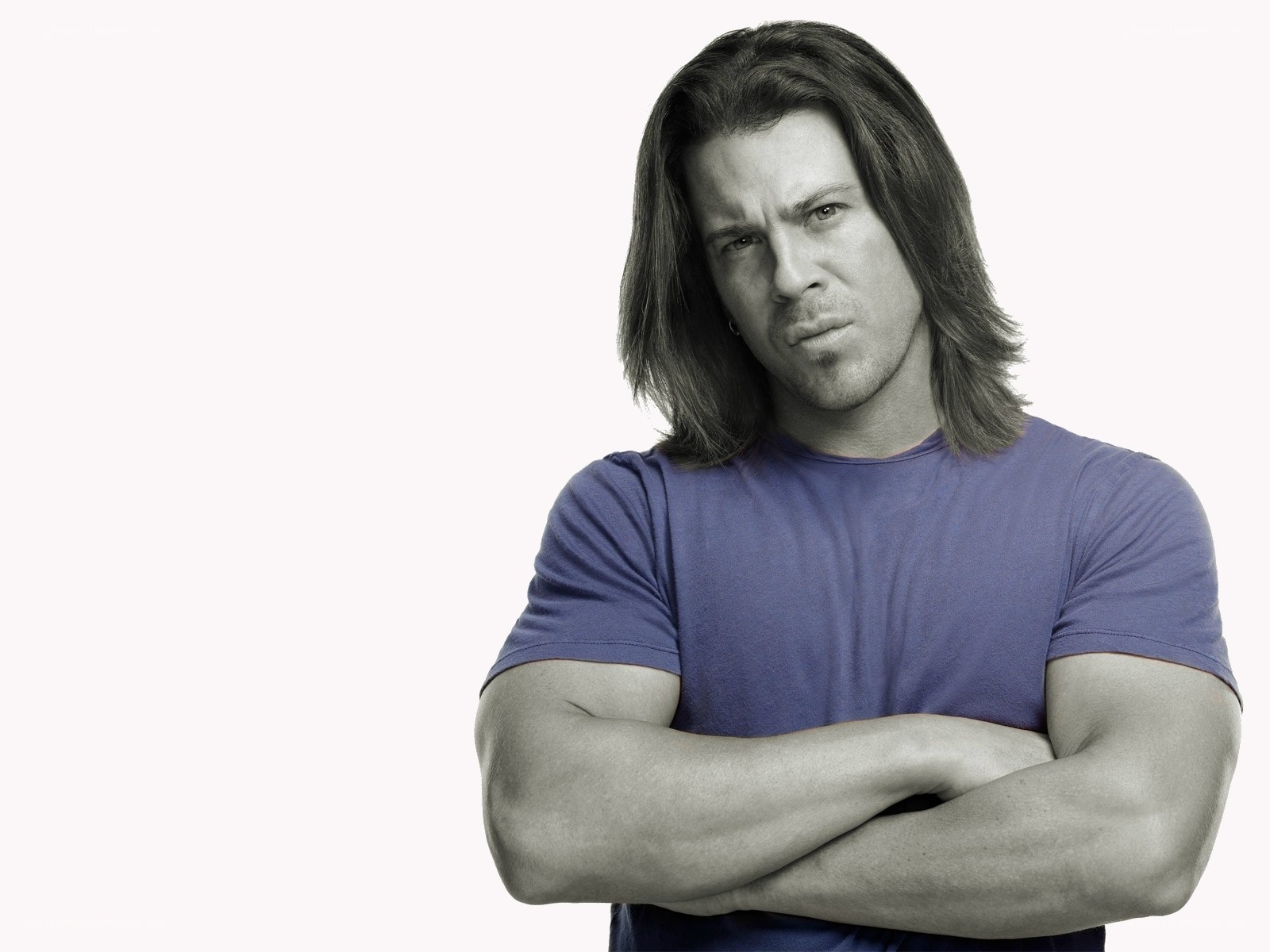 man with long hair and arms crossed