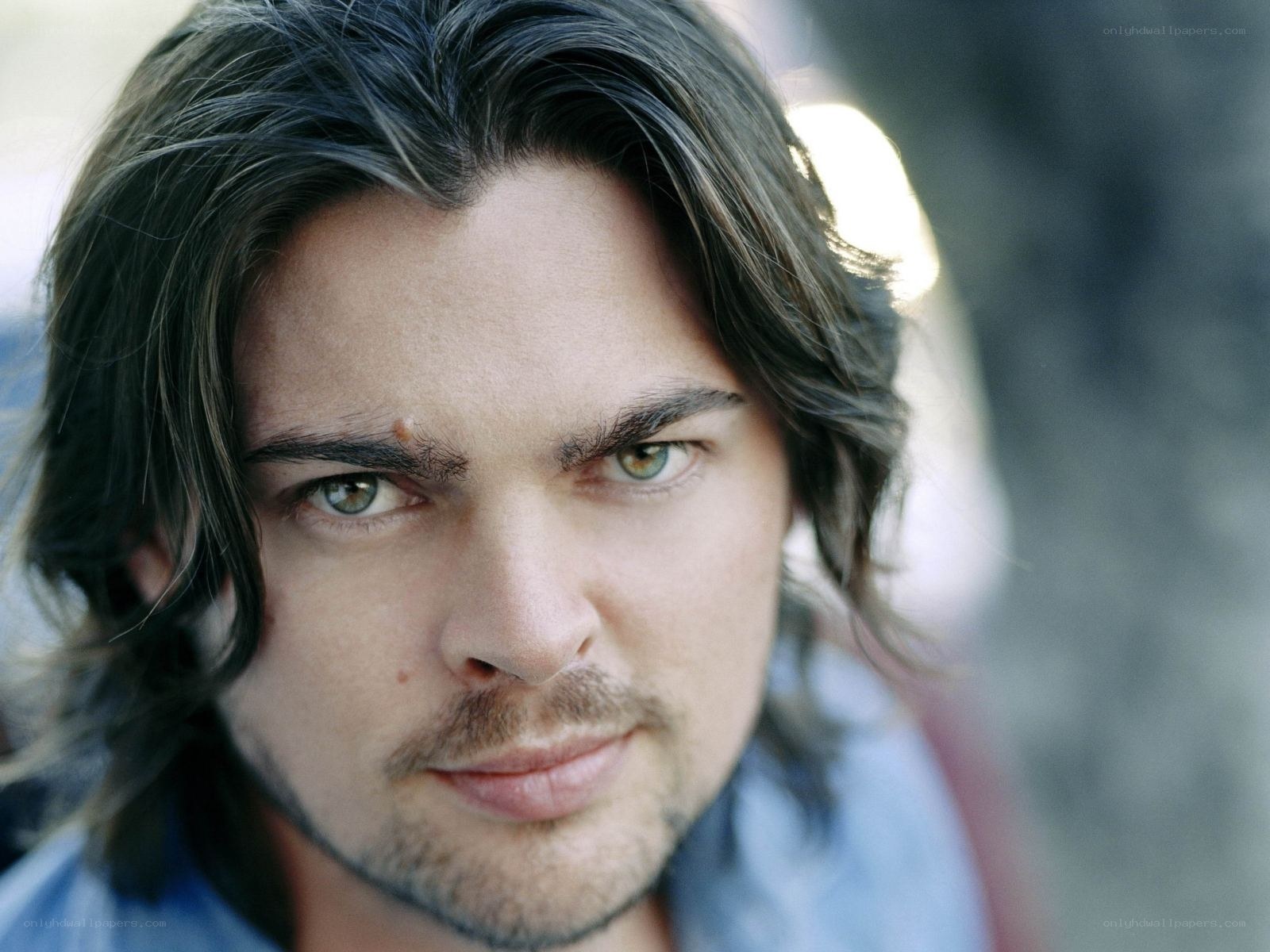 man with long hair and green eyes