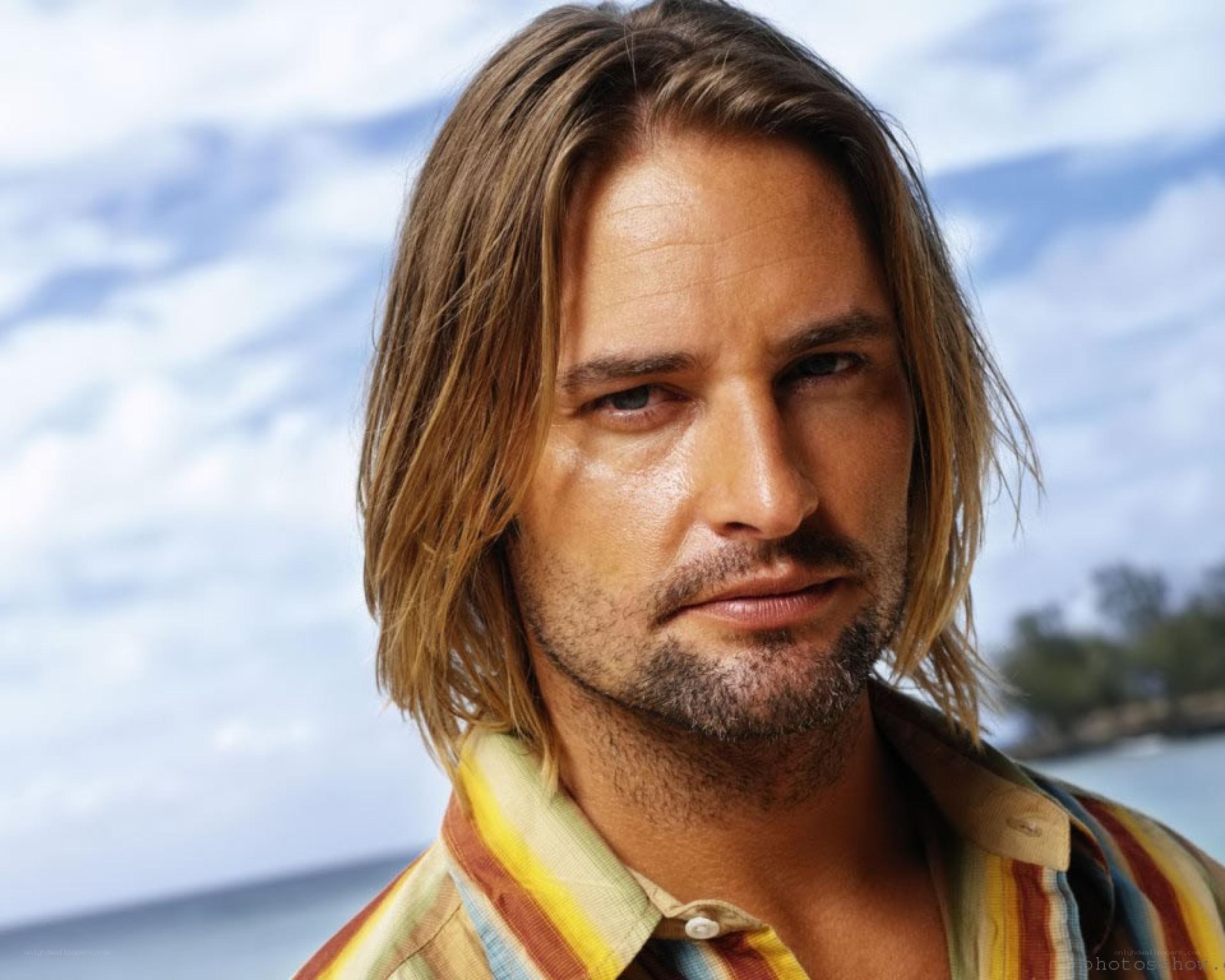 man with long hair at beach