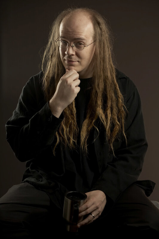 man with long hair holding mug