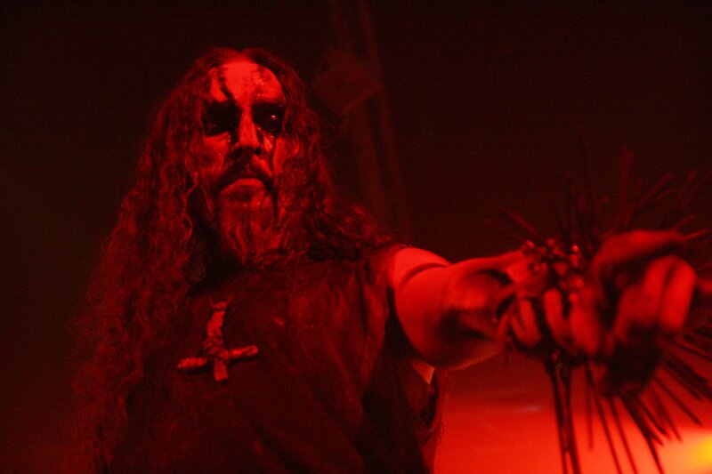 man with long hair holding spikes