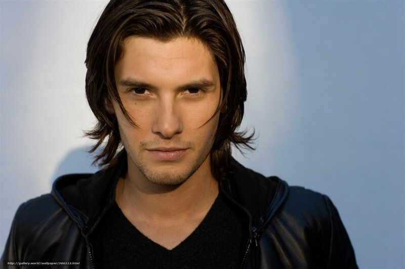 man with long hair in black jacket