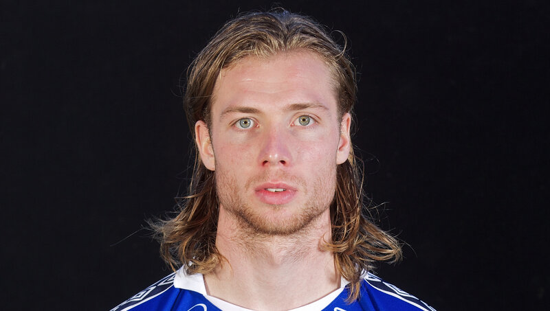 man with long hair in blue jersey