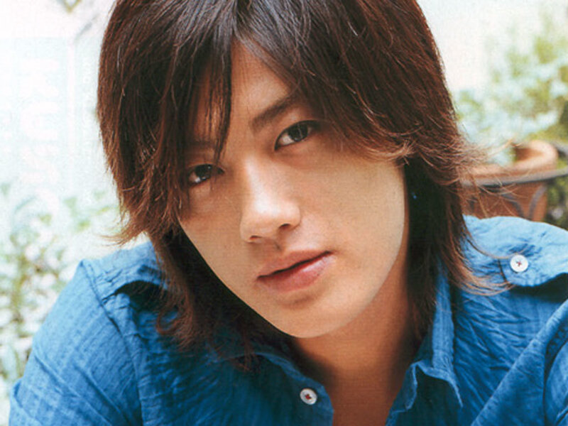 man with long hair in blue shirt
