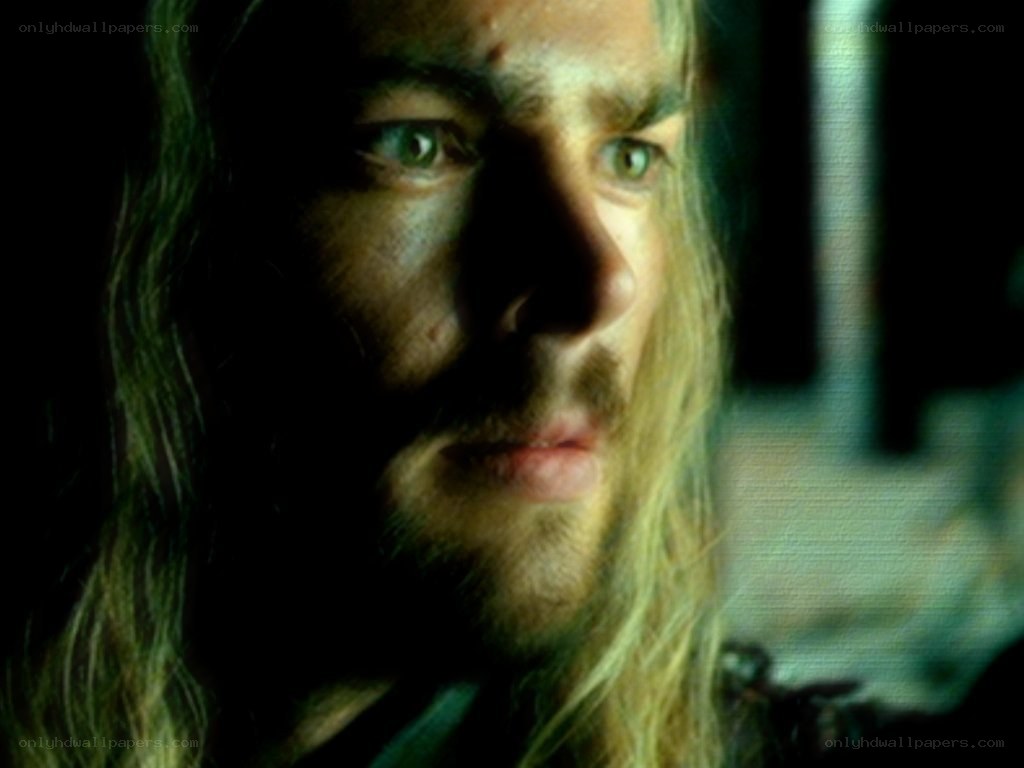 man with long hair in dim light