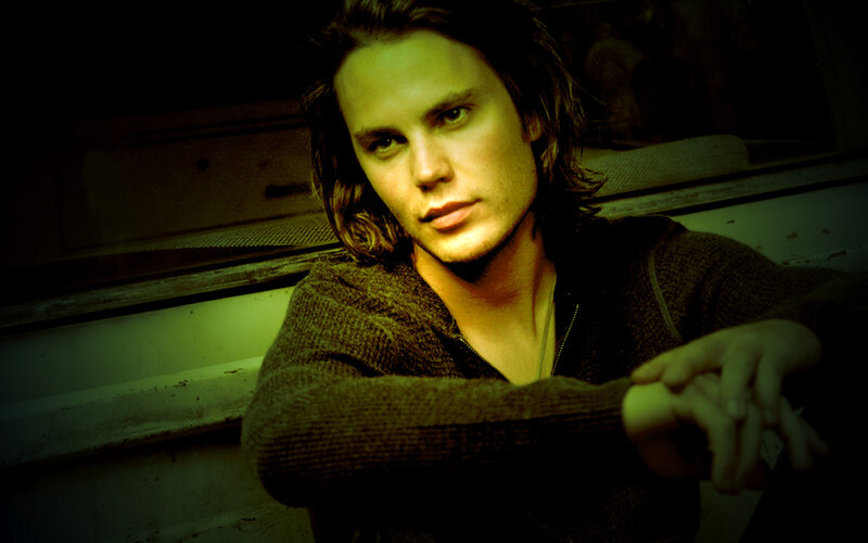 man with long hair in green light