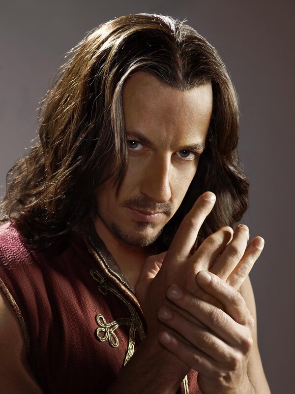 man with long hair in red tunic