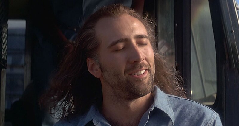 man with long hair in vehicle