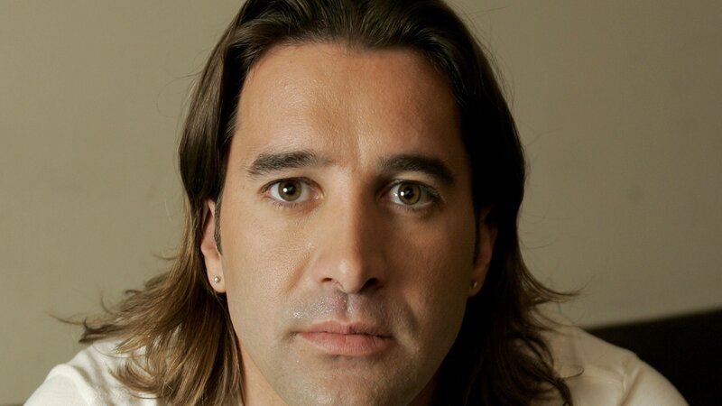 man with long hair looking at camera