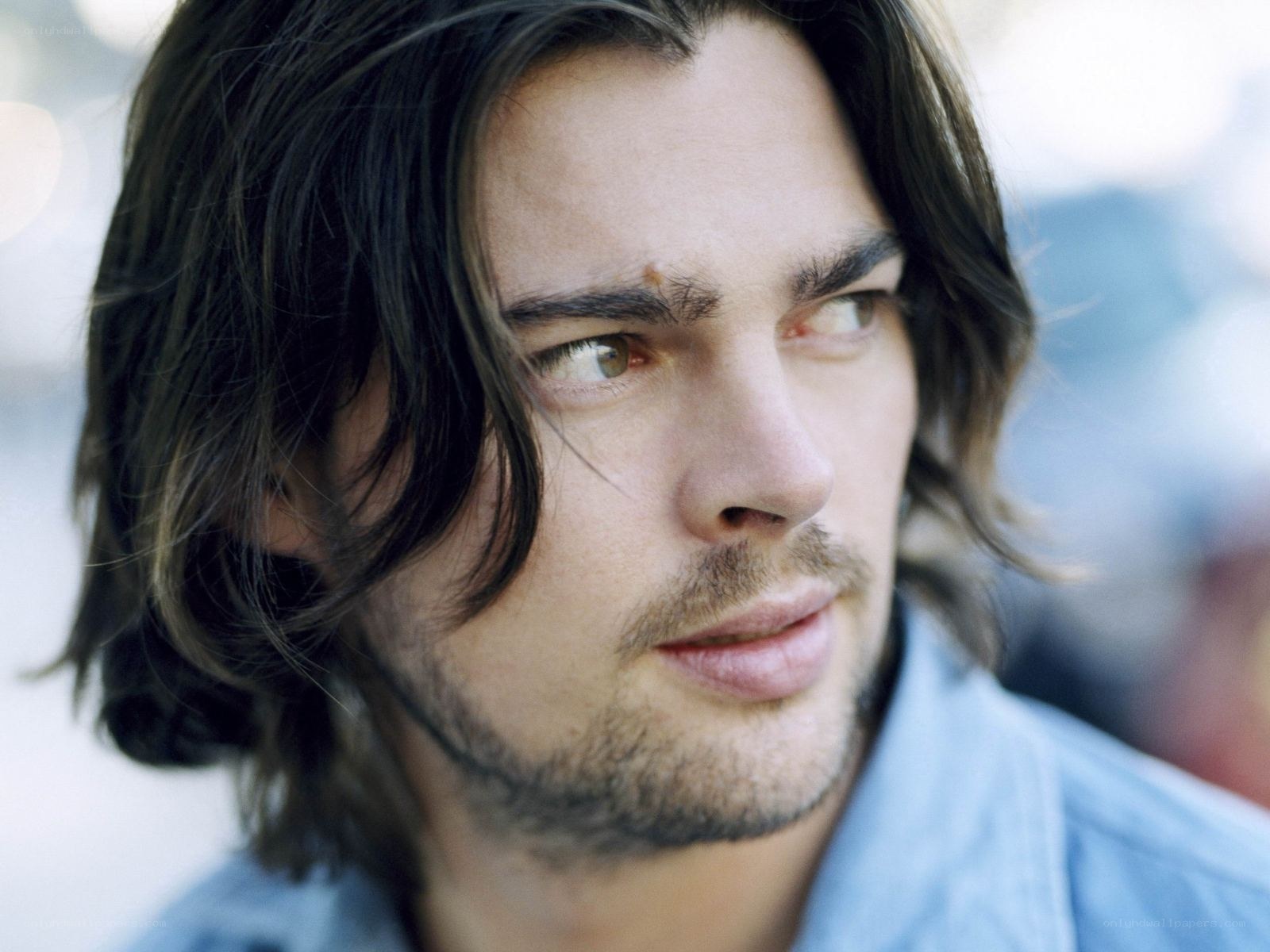 man with long hair looking away