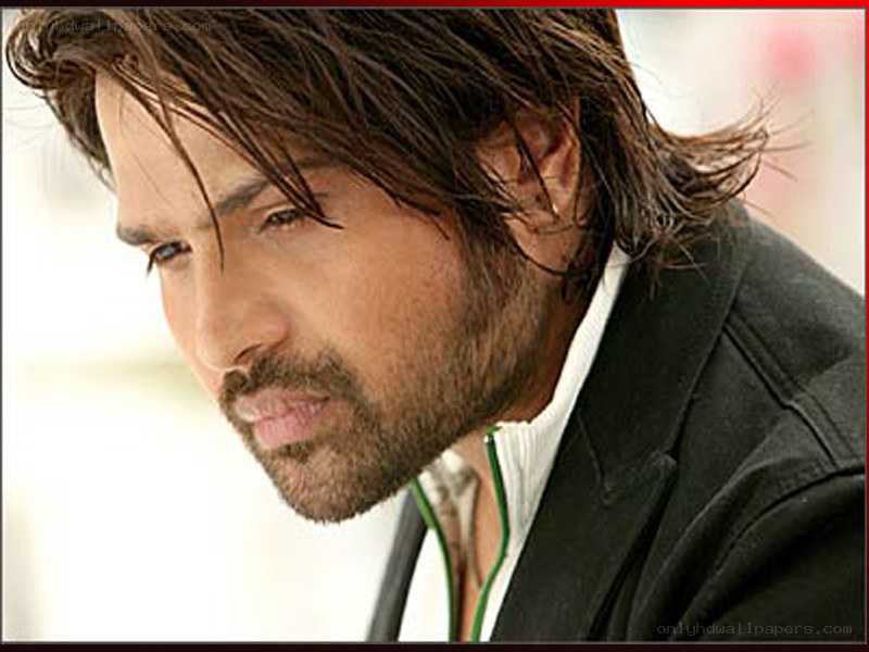 man with long hair looking down
