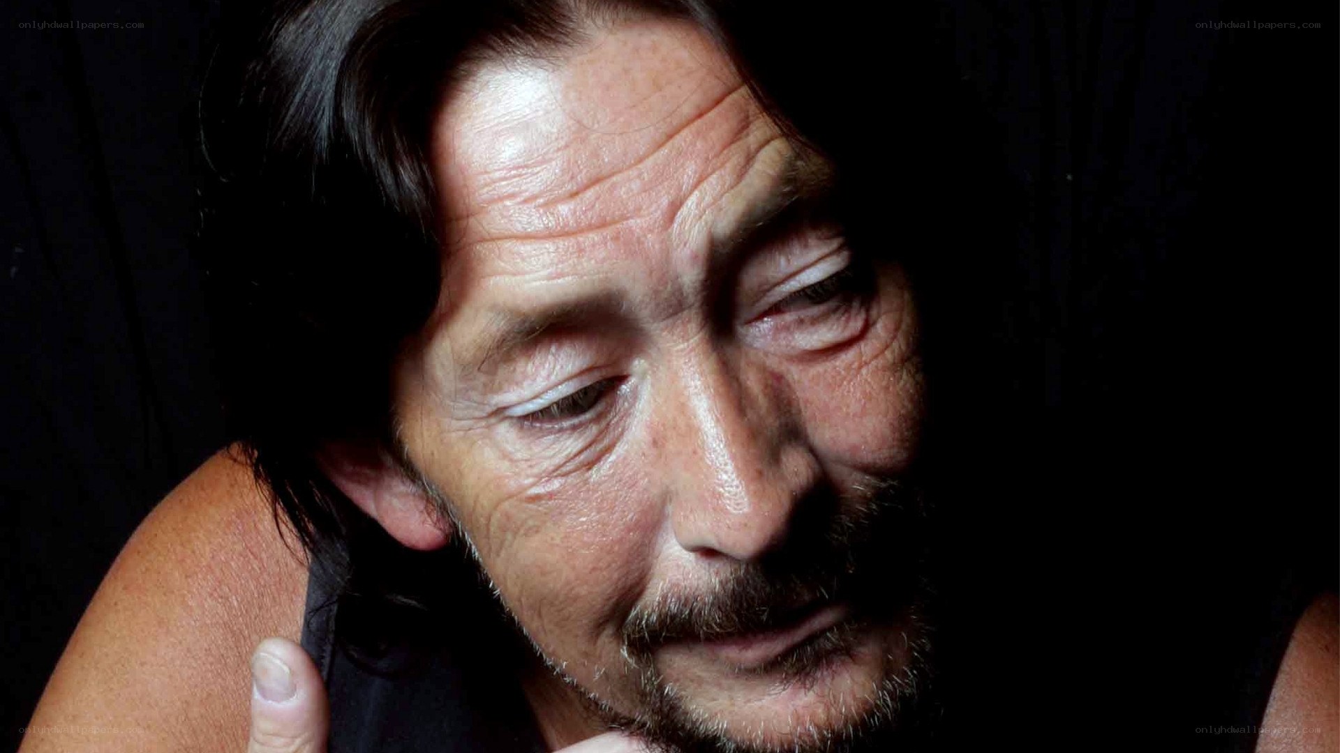 man with long hair looking down