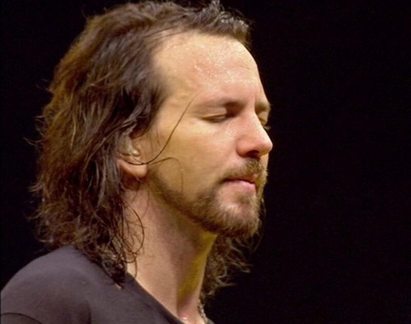 man with long hair on stage
