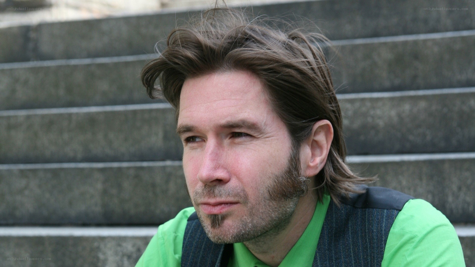 man with long hair sitting on steps