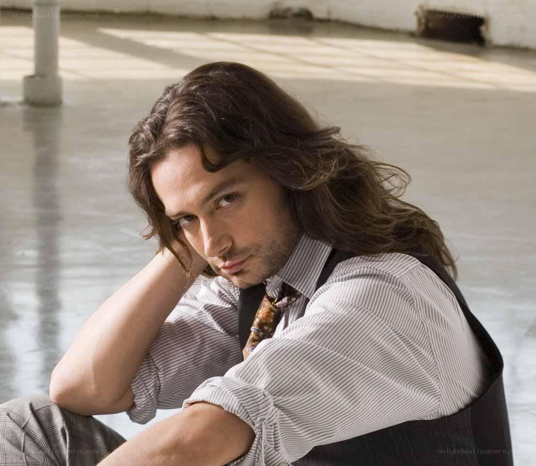 man with long hair sitting