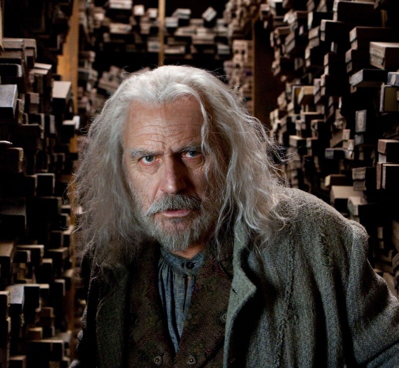 man with long white hair in library