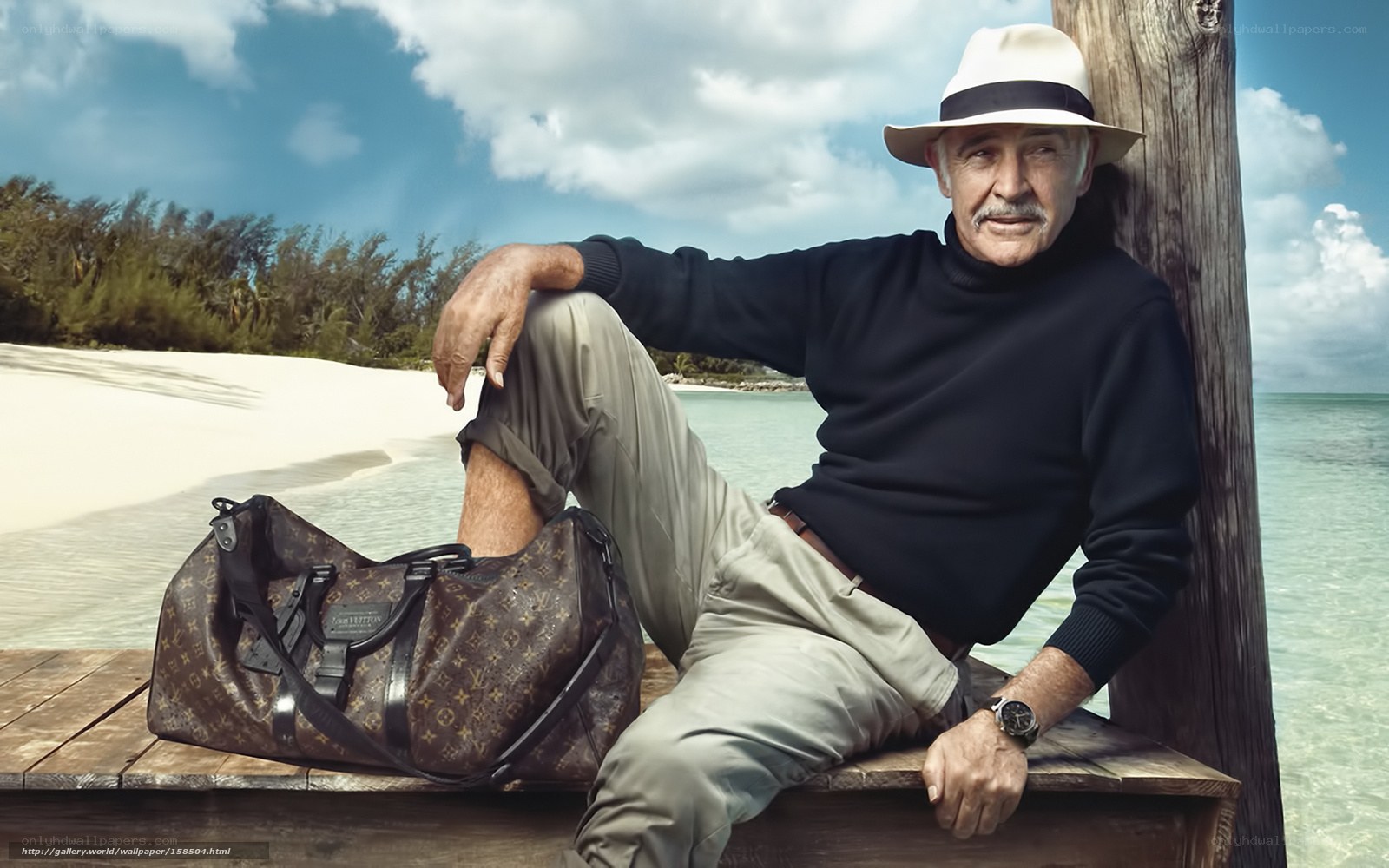 Man with Louis Vuitton bag on beach