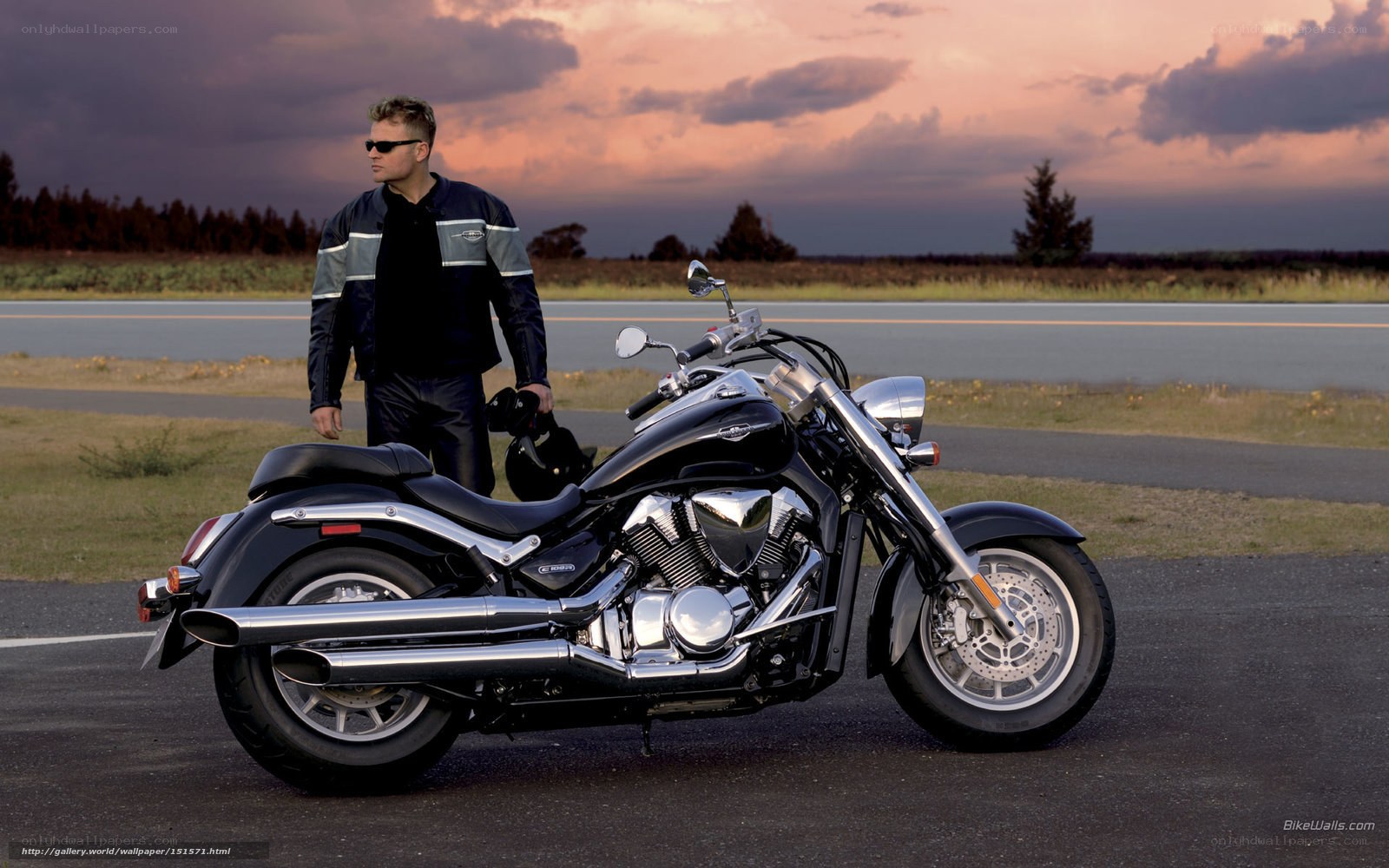 Man with motorcycle at sunset
