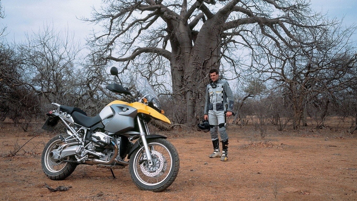 Man with motorcycle in savanna