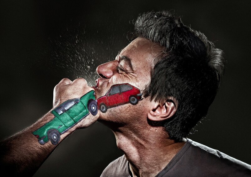 Man with painted cars on face and hand