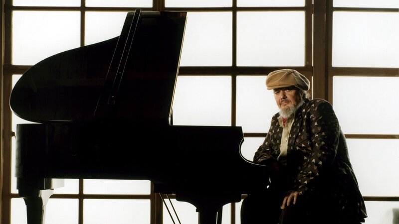 man with piano by window