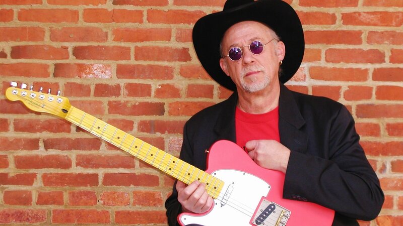 Man with pink guitar and hat