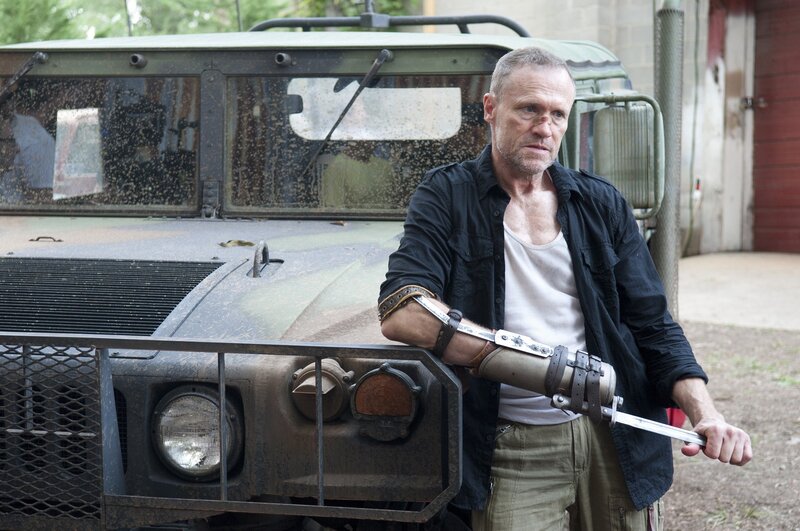man with prosthetic arm holding knife