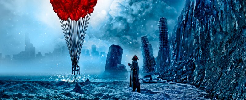 Man with red balloons in snowy landscape